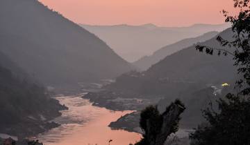 Sunset view of a river winding between mountains.