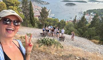 People posing with a panoramic view of the coastal town.
