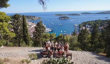 Group of people posing with a view of the sea and islands.