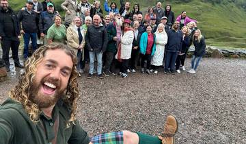 Large group of people posing together, one person in front taking a selfie.