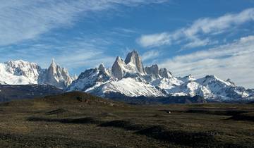 Snowy mountain range under a blue sky.