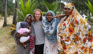 Women posing in traditional attire with a young child.