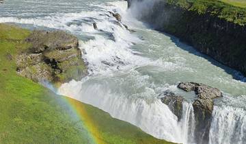 Waterfall with a visible rainbow over the landscape.