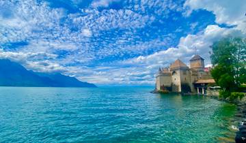 Castle on the edge of a lake with a vibrant sky.