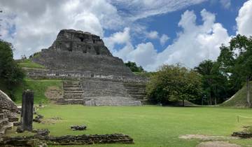 An ancient stone pyramid under a blue sky.