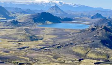 Vast aerial view of mountains and a lake in a serene landscape.