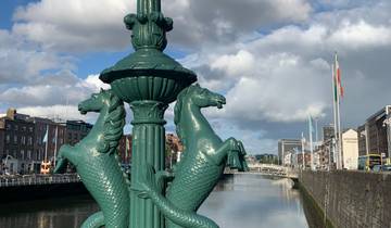 Decorative lamppost with horse statues by a river.