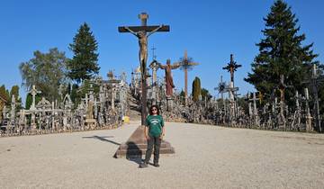 Person standing in front of the Hill of Crosses.