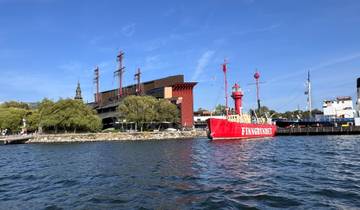 A harbor with a red ship and modern buildings.