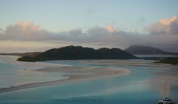 Idyllic landscape of islands with clear water and boats.