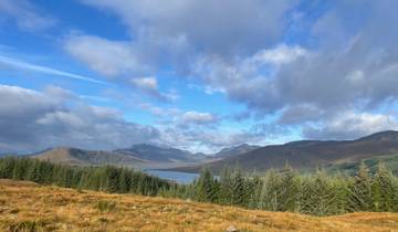 Scenic view of mountains and a lake with cloudy skies.