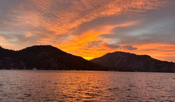 A breathtaking sunset over the sea with a silhouette of mountains.