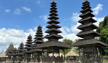Balinese temple with multiple tiered roofs and blue sky background.