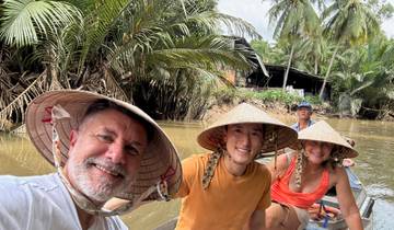 Group of people in traditional hats on a boat in a river.