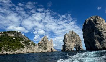 Beautiful rock formations in the sea under a partly cloudy sky.