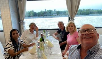 Group of people enjoying a meal with a scenic river view.
