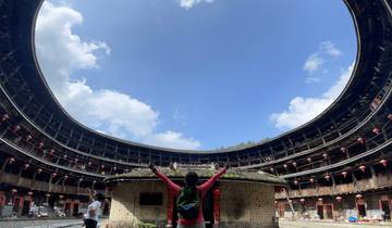 Person inside a circular structure raising arms to the sky.