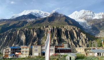 Village with colorful buildings against snow-capped mountains.