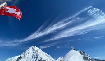 Snow-covered mountain peaks with a Swiss flag.