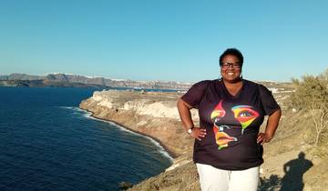 A person standing on a cliff with a scenic ocean view.