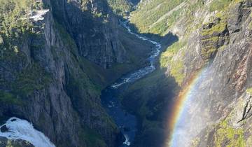 A waterfall cascading down a steep cliff with a rainbow.