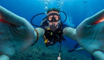 A scuba diver taking a selfie underwater.