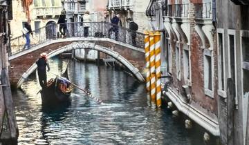 Gondola navigating a canal under a bridge in Venice.