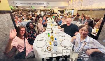 Group of diners at a large table in a busy restaurant.