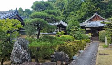 A traditional Japanese garden with a rock pathway and trimmed bushes.