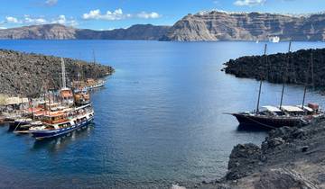 Boats docked in a serene bay with rocky shores.