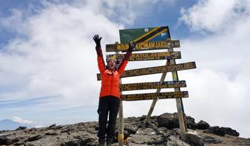 Person celebrating at the summit of Mount Kilimanjaro.