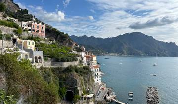 Coastal town built into steep cliffs with turquoise water.