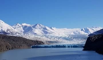Glacial lake with towering snow-capped mountains.