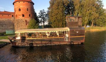 Old wooden boat near a red brick tower.