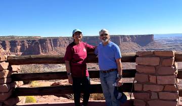 Two people posing in front of a canyon landscape.
