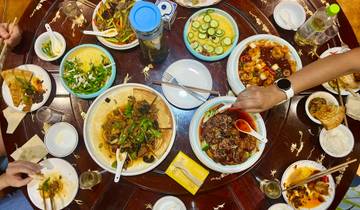 A table filled with various dishes and people dining.
