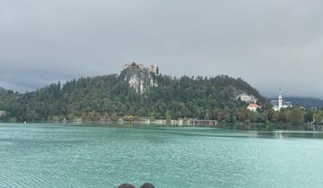 Scenic view of a lake with a castle on a hilltop.