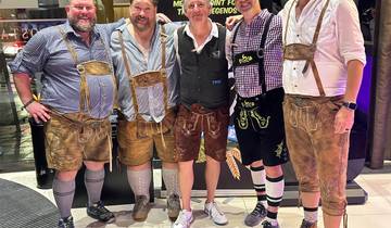 Men in traditional attire posing for a group photo indoors.