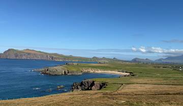 Coastal view overlooking a jutting peninsula and distant mountains.