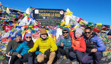 Group of people at Thorong La Pass with prayer flags