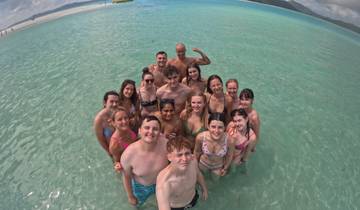 Group wading in crystal clear water smiling at the camera.