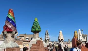 Colorful mosaic chimneys on a rooftop, iconic Gaudi design.