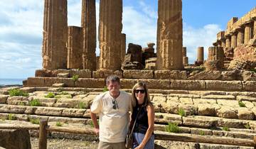 Two people posing in front of ancient temple ruins.