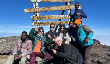 A group of climbers at Uhuru Peak, the summit of Mt. Kilimanjaro.