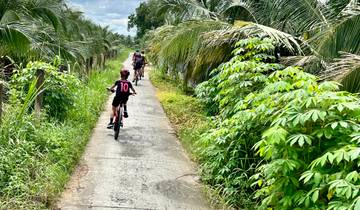 Cyclists riding along a lush, green path.