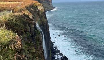 Coastal cliff with waterfall into the ocean.