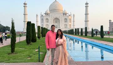 Couple posing in front of the Taj Mahal.