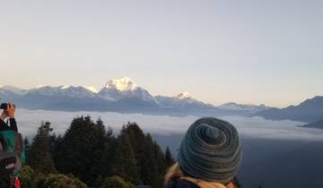 Tourists viewing snow-capped mountains above a sea of clouds