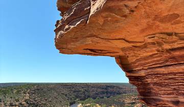 Rocky ledge overlooking a vast canyon landscape.