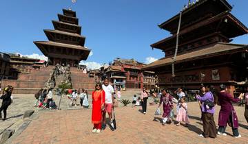 People walking around a historic square with traditional architecture.